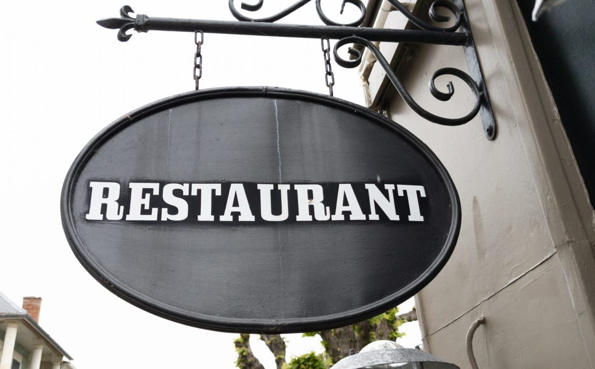 restaurant text sign on panel board facade building city street storefront